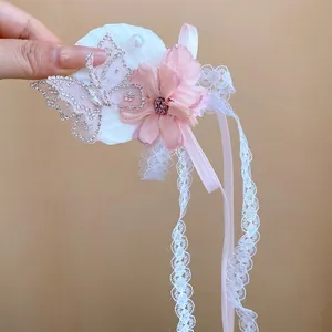Gedetailleerde weergave van haarclip met roze stoffen bloem, vlinder en kant