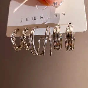 Geometric silver hoop earring set featuring three unique textured styles on card