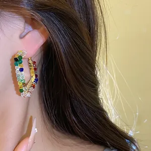 Close-up detail showing vibrant colorful glass beaded hoop earrings on a female model