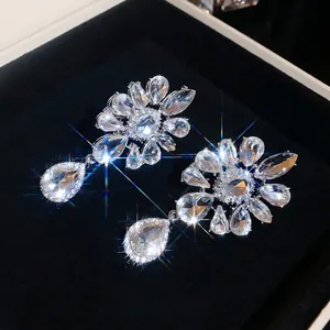 Elegant sparkling rhinestone flower teardrop clip-on earrings in a black luxury jewelry box
