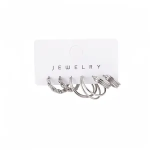 Set of three pairs of silver-colored geometric hoop earrings with textured and smooth finishes