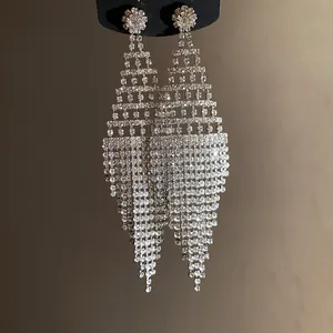 Silver tassel fringe earrings with dazzling rhinestones in an exaggerated rhombus shape.