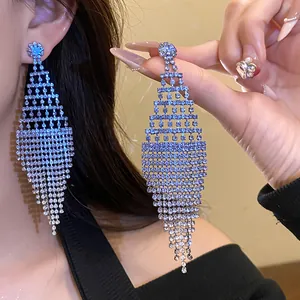 Close-up detail showing sparkling rhinestone rhombus tassel earrings on a model's ear.