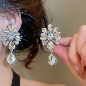 Detailed close-up showing elegant rhinestone flower waterdrop ear clips worn by a model