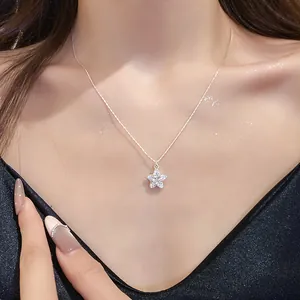Detailed macro shot of a sparkling zircon star pendant necklace on a model's neck.