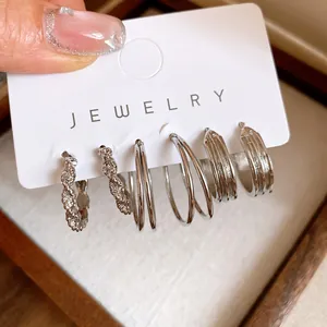 Detailed close-up view of silver geometric hoop earring set on jewelry display card