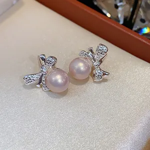 Detalle de cerca de los elegantes pendientes de lazo plateados con perlas lavanda