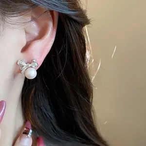 Detalle de un elegante pendiente de perla con lazo de estilo francés en la oreja
