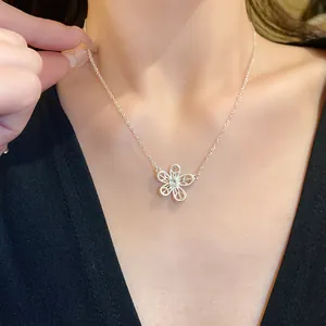 Close-up of a delicate hollow floral pendant necklace featuring a sparkling zircon