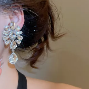 Close-up of rhinestone flower waterdrop ear clip earrings on a model