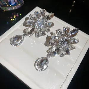 Detailed close-up view of shimmering flower and waterdrop rhinestone clip-on earrings