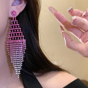 Detailed close-up showing pink rhinestone rhombus tassel statement earring on a model's ear