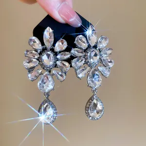 Detail shot of vintage luxury rhinestone flower and water drop clip-on earrings.