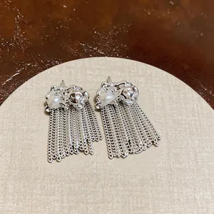 Macro dei orecchini a nappa d'argento con perle scaramazze e dettagli di catena