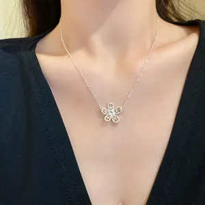 Detailed view of an elegant hollow flower pendant necklace with zircon center on model