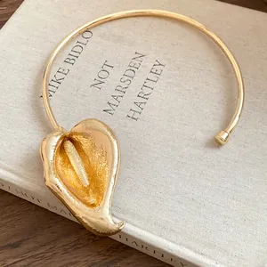 Detailed macro view of an elegant vintage gold calla lily flower choker necklace.