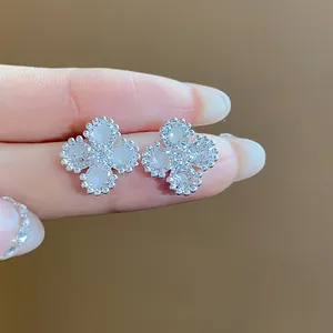 Primo piano di eleganti orecchini a lobo a fiore in argento con zirconi scintillanti