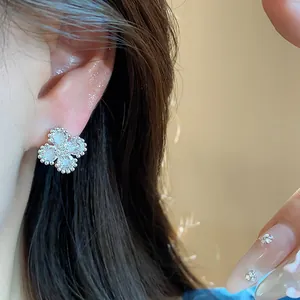 Dettaglio in primo piano di un elegante orecchino a fiore in zircone argento sul modello