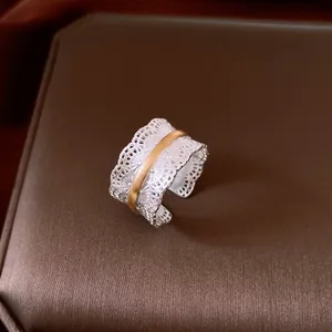 Close-up of vintage metal lace hollow open ring with two-tone silver and gold finish