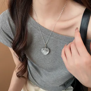 Élégant collier avec pendentif en cœur de cristal porté par un mannequin pour le quotidien.