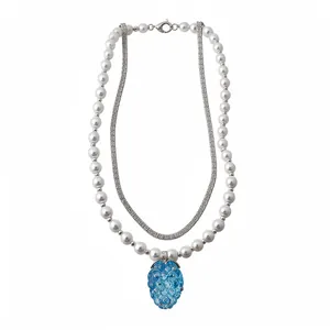 Elegant layered necklace featuring white pearls and a blue resin grape pendant.