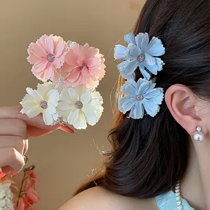 Vista dettagliata di eleganti mollette per capelli in tessuto a fiori rosa, bianchi e blu