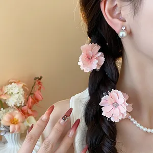 Primo piano di eleganti fermagli per capelli a fiori rosa in un'acconciatura a treccia