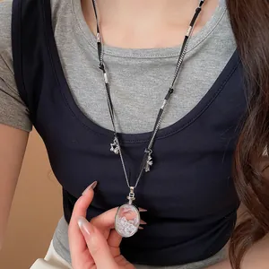 Gros plan d'un collier avec pendentif en croix et cristal sur un modèle.