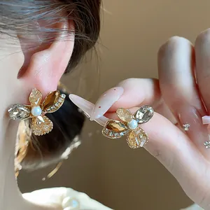 Close-up of elegant flower stud earrings with champagne glass petals and center pearl
