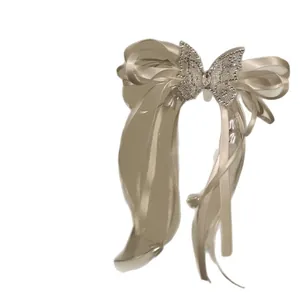 Elegant champagne satin ribbon bow hair clip with sparkling rhinestone butterfly tassel