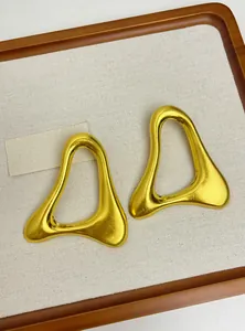 Vue détaillée de boucles d'oreilles géométriques creuses irrégulières au fini doré mat