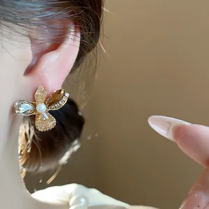 Elegant close-up showing the intricate glass flower stud earring with a central pearl