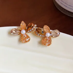 Macro view of elegant French style glass flower earrings with pearls and crystals.