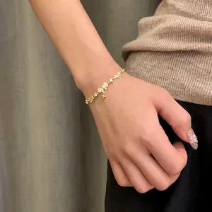 Detailed macro shot of an 18K gold-plated bow and star bracelet on a feminine wrist