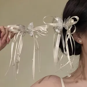 Side view of butterfly ribbon bow hair clip with crystal details and hanging tassels