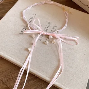 Pink beaded necklace with elegant ribbon bow and white flower charms for women