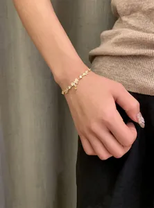Elegant 18K gold plated bracelet featuring zircon bow and star charms on a model's wrist