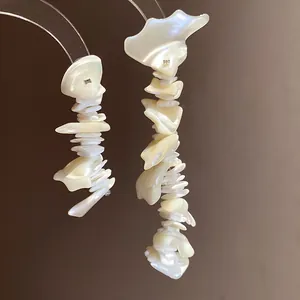 Close-up of bohemian irregular shell tassel earrings with an iridescent pearly luster