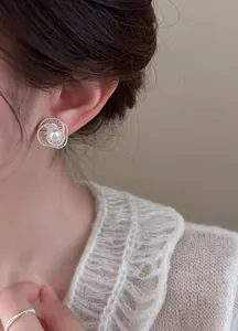 Detailed view of hollow thread pearl stud earring worn on ear, elegant silver design