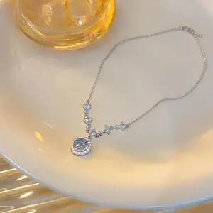 Detailed view of elegant silver necklace with round and square zircon pendant on a plate