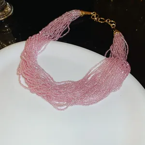 Elegante roze kralenketting met meerdere strengen en gouden roestvrijstalen sluiting.