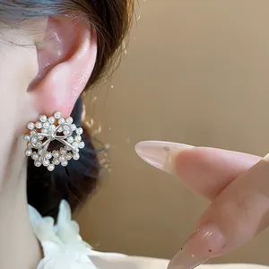 Close-up of elegant 14k gold-plated bow pearl stud earrings on ear for a delicate look