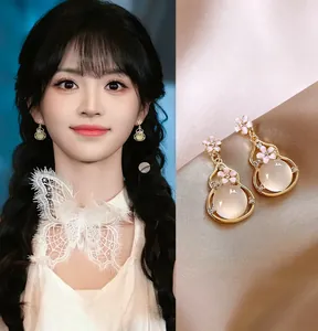 Elegant gold-tone gourd pendant earrings with pink enamel flowers and gemstone detail