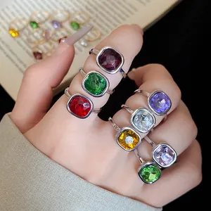 Close-up of vintage square rings with colorful gemstones on fingers for detailed view