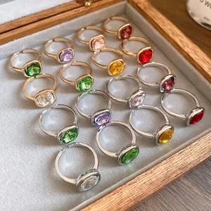 Close-up detail of vintage square cut gemstone adjustable rings in a wooden jewelry box