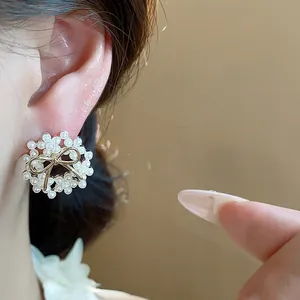 Macro detail shot showing the delicate 14k gold-plated bow and pearl earring on ear