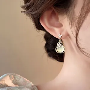 Close-up detail of vintage palace style gourd drop earring with flower motif decoration