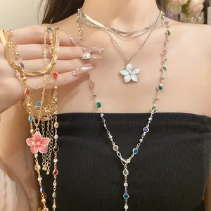Primo piano di una collana vintage a più strati con pietre colorate e pendente a fiore