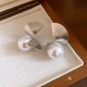 Vue détaillée de boucles d'oreilles perles et métal torsadé dans un écrin en bois vintage