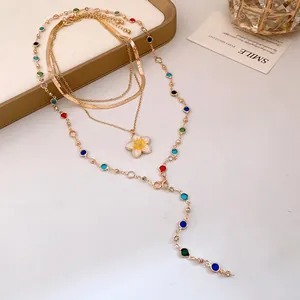 Vista dettagliata della collana dorata a più strati con ciondolo a fiore e perline